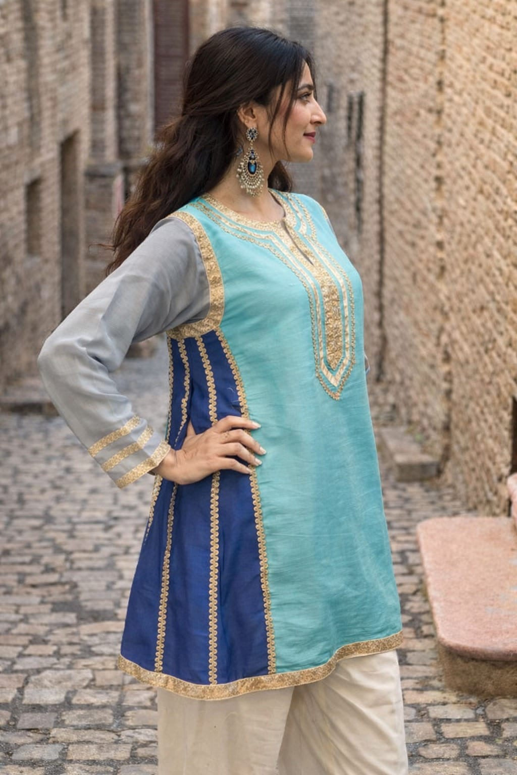 Kareena Kapoor inspired traditional outfit with a blue and green top with gray sleeves and beige pants.