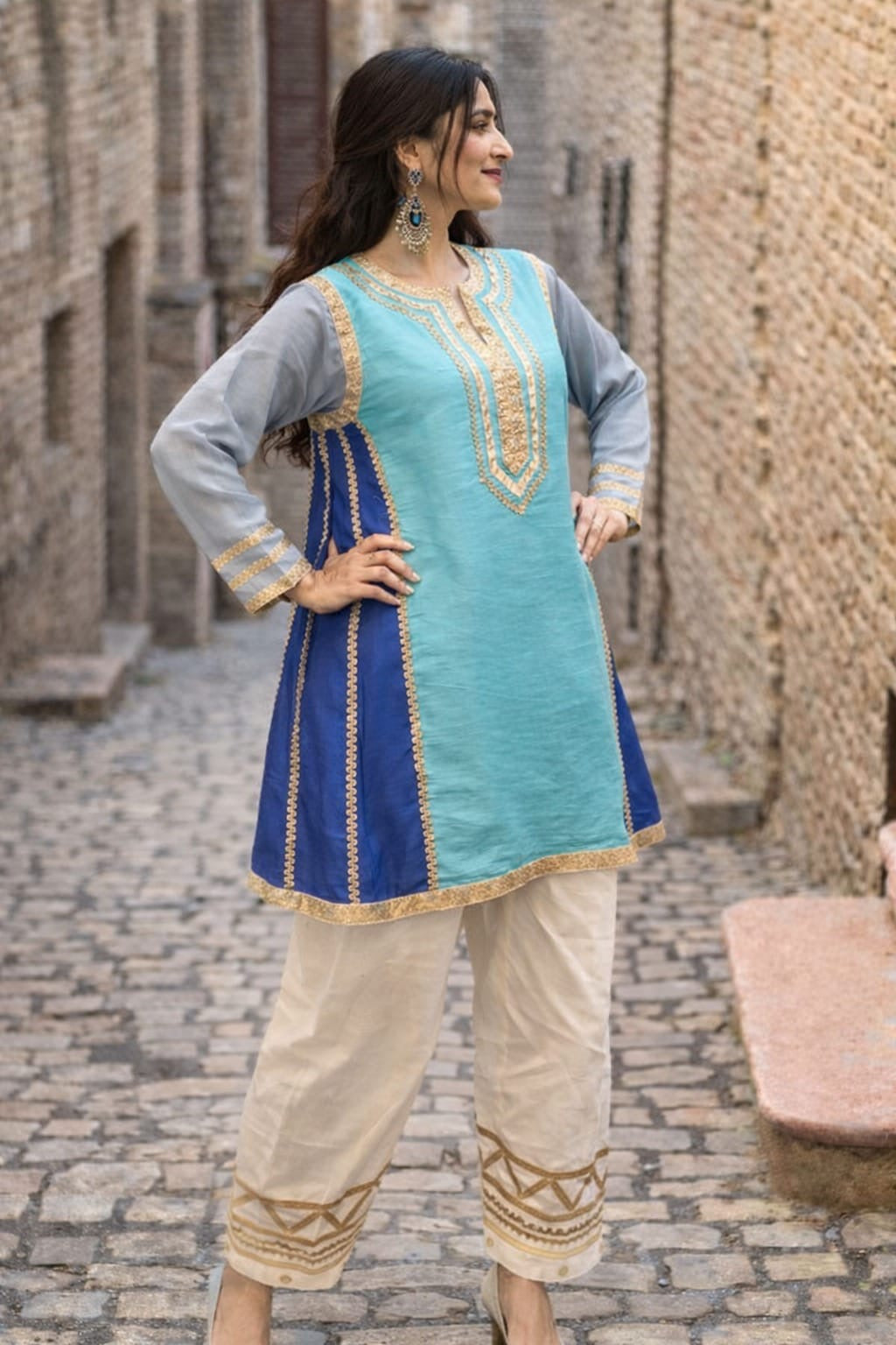 Kareena Kapoor inspired traditional outfit with a blue and green top with gray sleeves and beige pants.