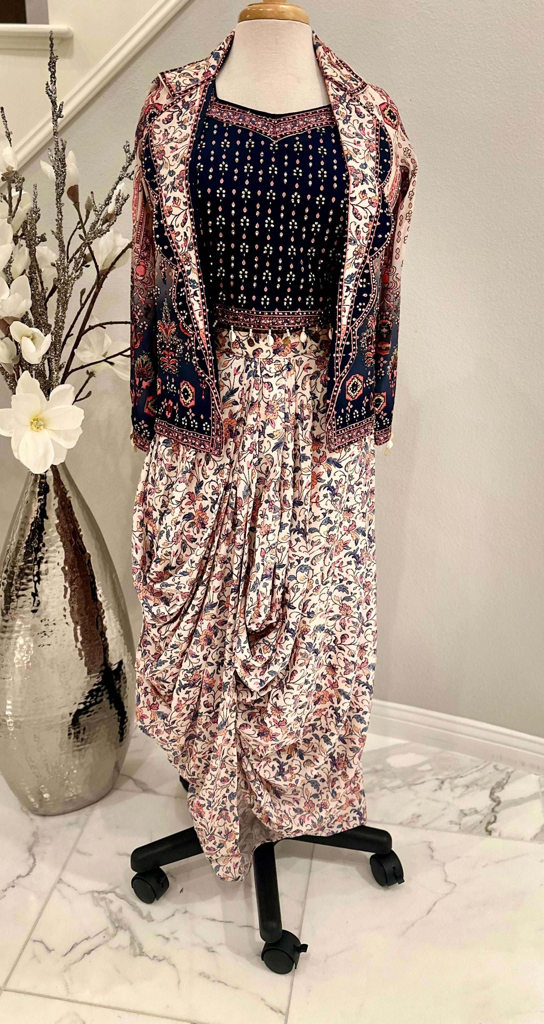 Shine bright with this beautiful 3piece ensemble in pure silk and digital floral print with rhinestone work all over.  The set includes dhoti style skirt, rhinestone embellished crop-top and jacket with front lapel

Size available 40 with margin