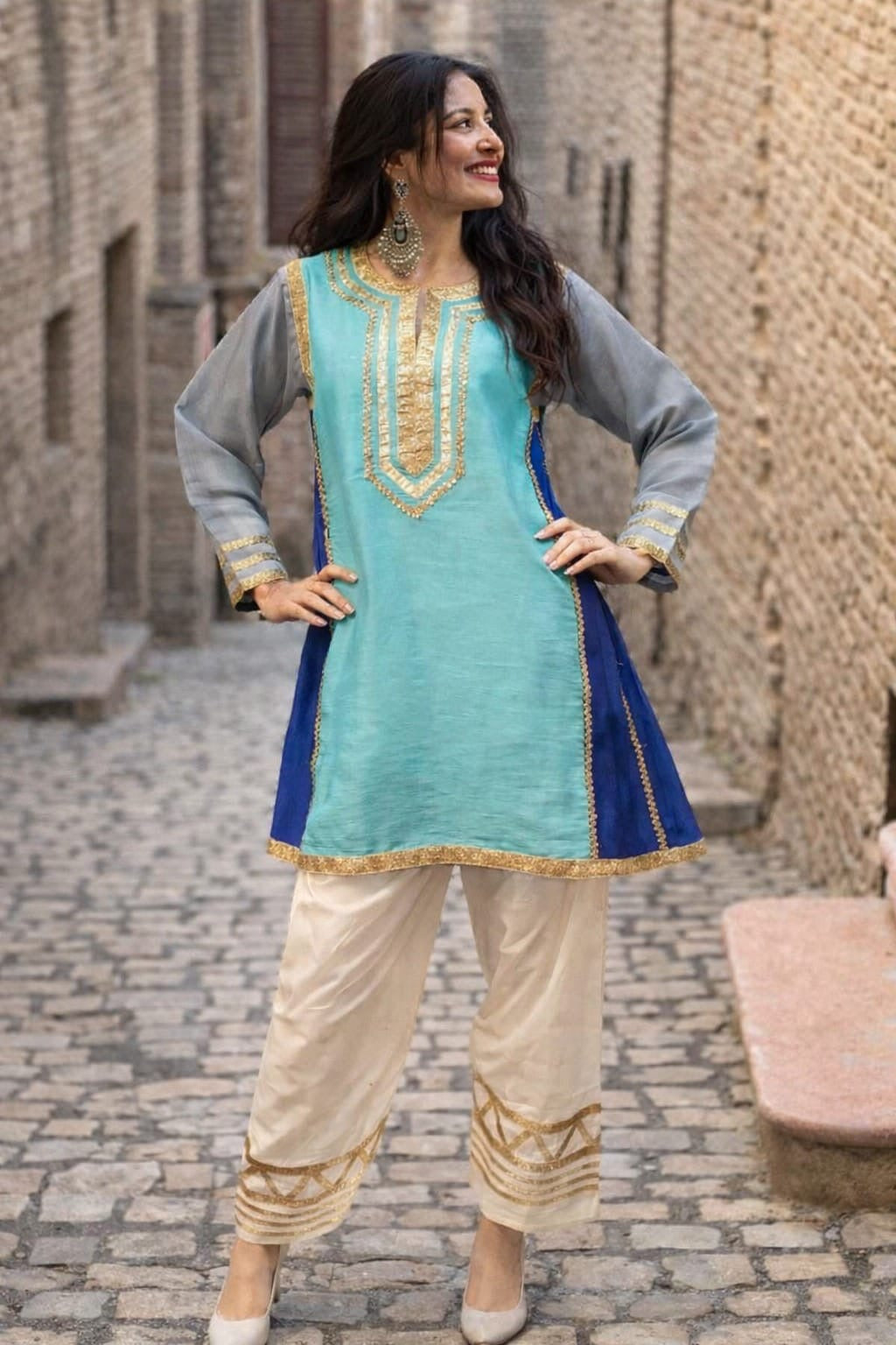 Kareena Kapoor inspired traditional outfit with a blue and green top with gray sleeves and beige pants.