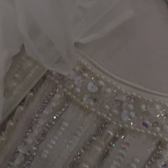 Beautifully crafted 3 piece shrug set in pure silk with pearl embellishment on the asymmetrical crop-top. Paired with long open shrug  in soft organza with pearl lace on the open edges. Paired with a plain white pleated front skirt

Size available 38 with margin.