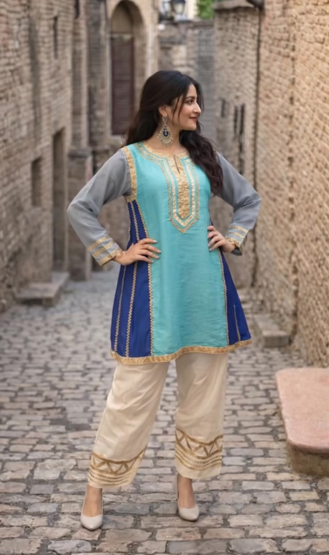 Kareena Kapoor inspired traditional outfit with a blue and green top with gray sleeves and beige pants.